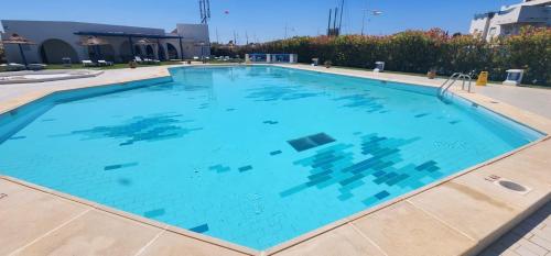 a large swimming pool with blue water at Appartement marina hammamet in Hammamet