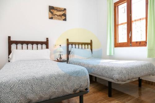 1 dormitorio con 2 camas y ventana en Eucaliptus - Casa en el Delta para disfrutar de la playa del Trabucador - Deltavacaciones, en L'Eucaliptus