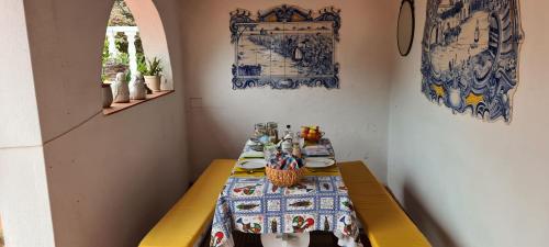 ein Esszimmer mit einem Tisch und Teller mit Lebensmitteln in der Unterkunft Casa das Margaridas in Caldas da Rainha