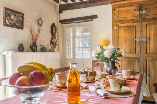 - une table avec un bol de fruits et une bouteille de bière dans l'établissement Le Pont de Benneville, à Cahagnes
