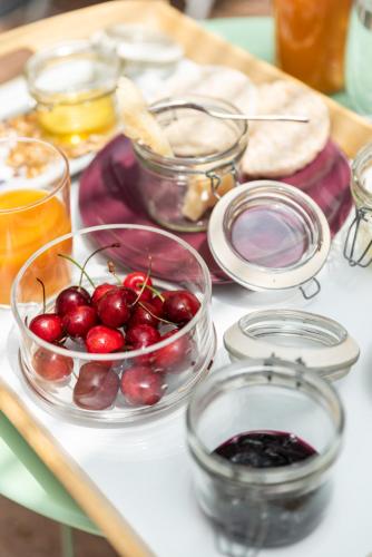 a table topped with bowls of cherries and other foods at Hotel Suite Inn in Udine