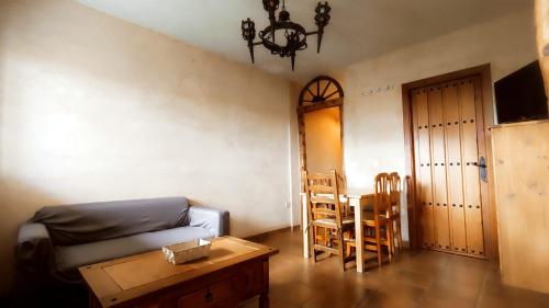 a living room with a couch and a table and chairs at LAS CALLEJUELAS in Atienza