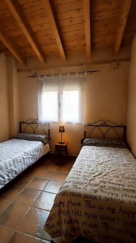 two beds sitting in a room with a window at LAS CALLEJUELAS in Atienza