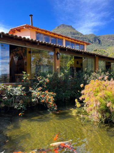 a house with a pond in front of it at Pousada do Capão Chapada Diamantina in Vale do Capao