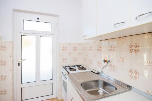 een kleine keuken met een wastafel en een fornuis bij Violic Apartments in Zaton