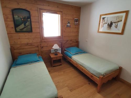 a room with two beds in a wooden cabin at Appartement Crest-Voland, 3 pièces, 6 personnes - FR-1-733-122 in Crest-Voland