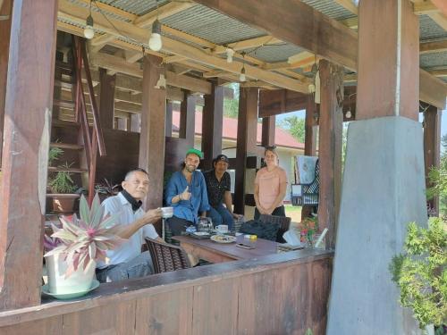 a group of people sitting around a table on a patio at Toraja Homestay & Coffee Bunna in Rantepao