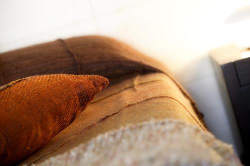 a close up of a pillow on a couch at Hotel Suite Inn in Udine