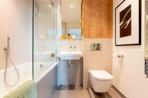 een badkamer met een toilet, een wastafel en een douche bij Spacious and Stylish 3-Bedroom Flat in Cro, London ER2 in South Norwood