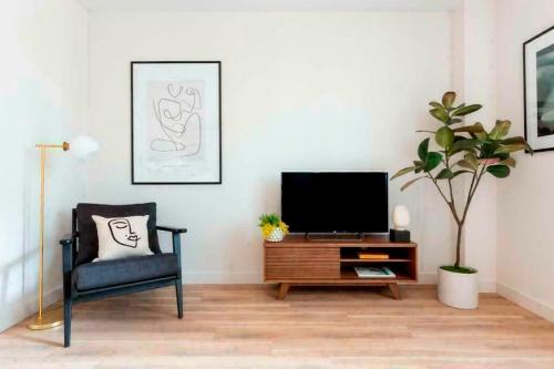 a living room with a tv and a chair at Spacious and Stylish 3-Bedroom Flat in Cro, London ER2 in South Norwood