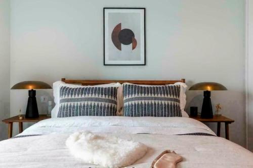 Spacious and Stylish 3-Bedroom Flat in Cro, London ER2 في South Norwood: شخص يستلقي على سرير وعليه منشفة
