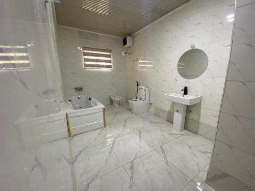 a white bathroom with a sink and a toilet at MOK Apartments & Suites in Lagos