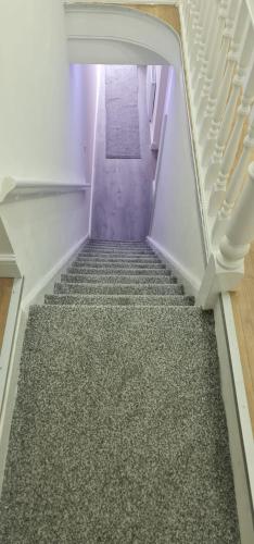 Una escalera con suelo de moqueta en una casa en ASM One Bedroom Apartment (Flat 11) en Leicester