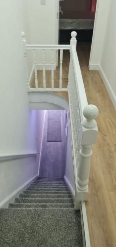 a stairway with a white railing and a purple staircase at ASM One Bedroom Apartment (Flat 11) in Leicester