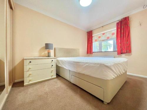 1 dormitorio con 1 cama, vestidor y ventana en Spacious and Stylish 3-Bedroom Flat in Cro, London ER2 en South Norwood