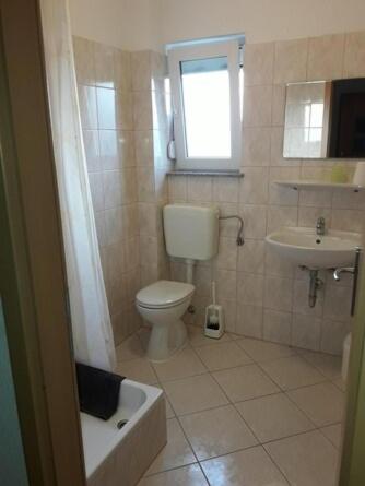 a small bathroom with a toilet and a sink at Apartmani Manuela Ljubač in Ljubač