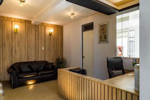 - un salon avec un canapé et une chaise dans l'établissement ESCALA BUSINESS HOTEL, à Chiclayo