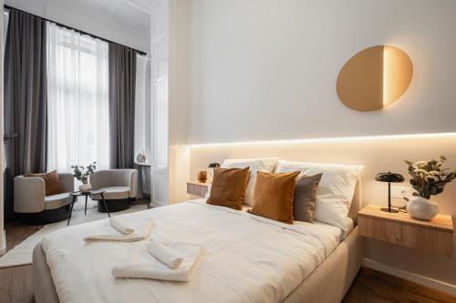 a bedroom with a large white bed with two towels on it at You Boutique Suites, Best Location by BQA in Budapest