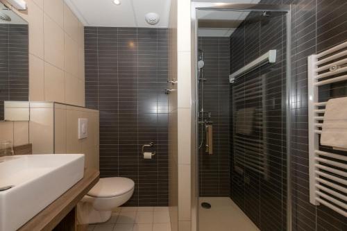 La salle de bains est pourvue de toilettes, d'un lavabo et d'une douche. dans l'établissement VTF L'Hotel Des Bains, à Saint-Cast-le-Guildo