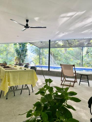 a dining room with a yellow table and chairs at Balai Benedicere Bed & Breakfast in Bacnotan