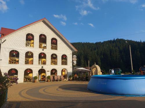 a large white building with a large blue tub in front of it at "Як вдома" Буковель in Bukovel