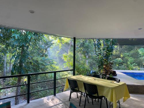 a dining room with a table and chairs on a balcony at Balai Benedicere Bed & Breakfast in Bacnotan