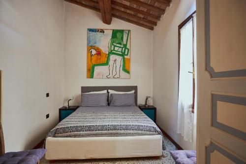 1 dormitorio con 1 cama y una pintura en la pared en Bassano Porta Dieda en Bassano del Grappa