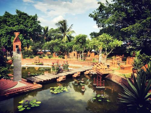 a garden with a pond with lilies and a bridge at KA VILLA - AN BANG BEACH, Free pick up 3 nights in Hoi An