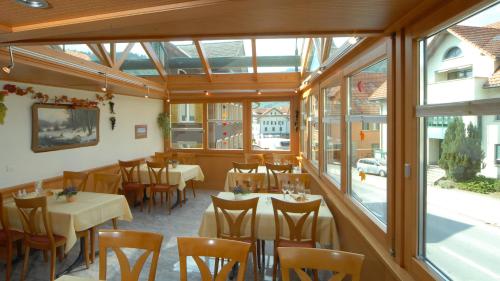 a restaurant with tables and chairs and windows at Gasthaus Engel Hasle in Hasle