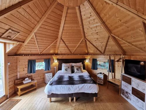 1 dormitorio en una cabaña de madera con 1 cama en Domaine de Kérizel, en Ambon