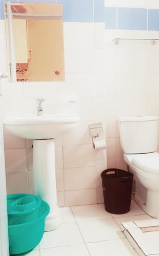 ein Bad mit einem Waschbecken und einem WC in der Unterkunft Monika's Bliss Apartment in Nairobi