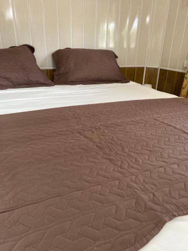 a large bed with a brown blanket on it at Tropical View in Spanish Lookout