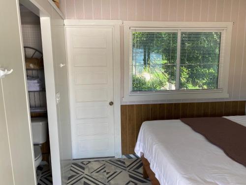 um pequeno quarto com uma cama e uma janela em Tropical View em Spanish Lookout