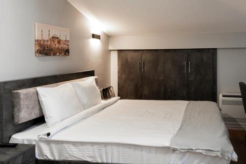 a bedroom with a large white bed with wooden cabinets at BRANDROOM HOTEL in Istanbul