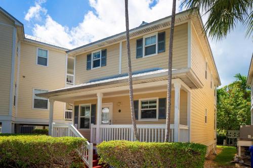 a house with palm trees in front of it at Coral Hammock Poolside Home in Key West