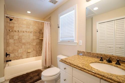 a bathroom with a toilet and a sink and a shower at Coral Hammock Poolside Home in Key West