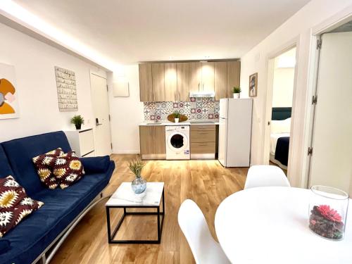 un soggiorno con divano blu e una cucina di Exclusive Apartment in Historic Center a Madrid