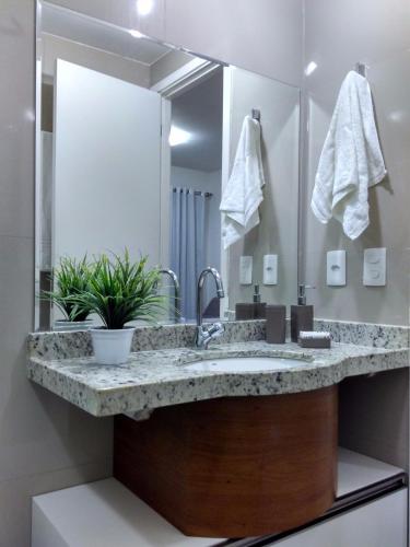 a bathroom with a sink and a large mirror at VG Fun Beach Front Apartamentos in Fortaleza