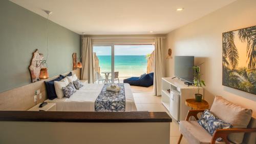 a living room with a bed and a view of the ocean at Pousada Dona Moça in Morro de São Paulo