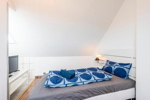 1 dormitorio con 1 cama con almohadas azules en EXQUIS 2,5 BR Maisonette I Familien I TOP-Location I Netflix I Mercedes-Benz, en Böblingen