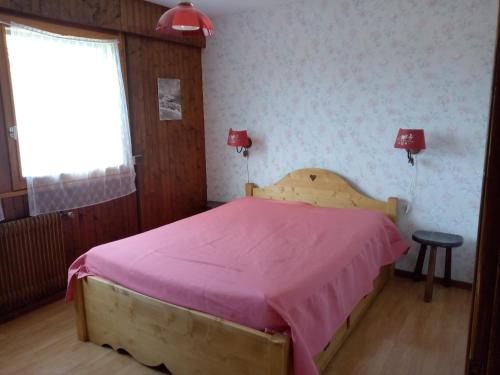 - une chambre avec un lit avec des draps roses et une fenêtre dans l'établissement Appartement cosy au Chinaillon, proche commerces et pistes, 4 pers, animaux admis. - FR-1-467-69, au Grand-Bornand