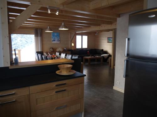 une cuisine avec un réfrigérateur et un salon dans l'établissement Chalet spacieux pour 10 personnes avec parking et animaux admis - FR-1-467-71, au Grand-Bornand
