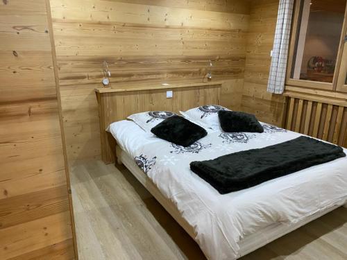 a bedroom with a large bed with white sheets and black pillows at Appartement Le Grand-Bornand, 4 pièces, 8 personnes - FR-1-467-53 in Le Grand-Bornand