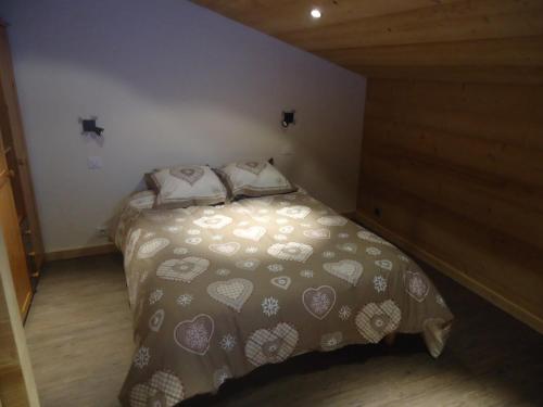 een kleine slaapkamer met een bed met harten erop bij Appartement Le Grand-Bornand, 2 pièces, 5 personnes - FR-1-467-26 in Le Grand-Bornand