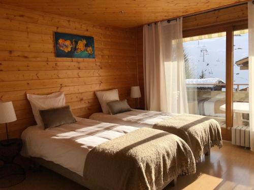 a bedroom with two beds in a log cabin at Appartement Le Grand-Bornand, 3 pièces, 9 personnes - FR-1-467-98 in Le Grand-Bornand