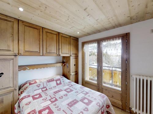 une chambre avec un lit et une grande fenêtre dans l'établissement Appartement 2 chambres avec balcon et parking proche pistes - FR-1-467-47, au Grand-Bornand