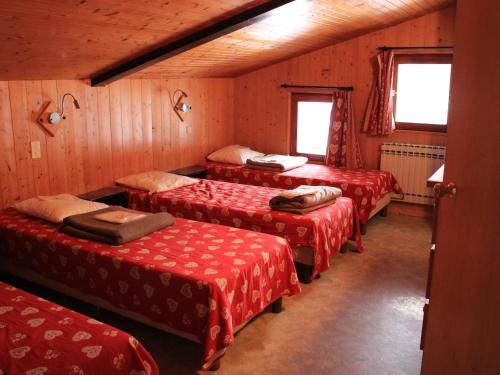 Cette chambre comprend 4 lits avec des draps rouges. dans l'établissement Appartement 10 pers avec piscine couverte près des pistes et services pratiques au Grand-Bornand - FR-1-467-105, au Grand-Bornand