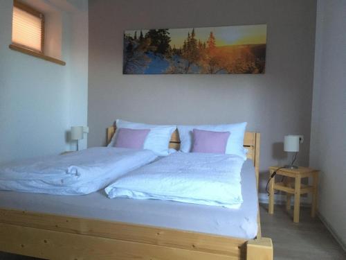 1 dormitorio con 1 cama con sábanas blancas y almohadas rosas en Ferienwohnung mit Aussicht im Bergdorf Steibis im Allgäu, en Steibis
