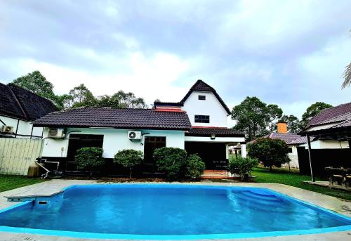Kampong Alor GajahにあるPrivate 4Bedroom Villa Pool,BBQ,Karaoke, Afamosa Resortの青いスイミングプールが目の前にある家