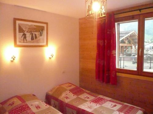 une chambre avec un lit et une fenêtre dans l'établissement Appartement cosy 7 pers avec piscine, près des pistes et du centre, Le Grand-Bornand Village - FR-1-467-106, au Grand-Bornand